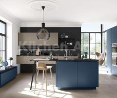 Cuisine ouverte chic équipée avec ilot central et façades mates bleu océan